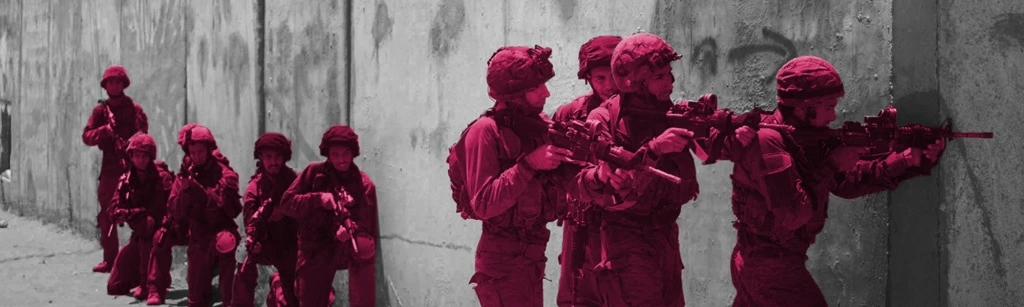 A photo of 9 Israeli soldiers holding guns during a training exercise.